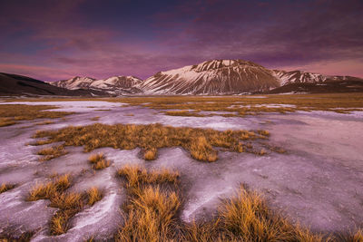 Scenic view of snowcapped mountains against sky during sunset