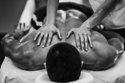 Cropped image of man massaging male customer at spa