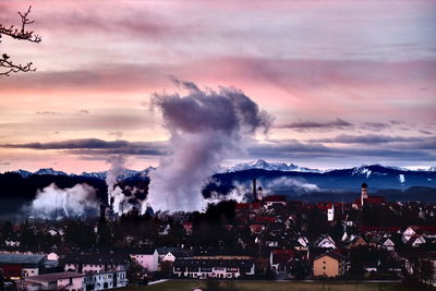 Smoke emitting from old town against sky during sunset