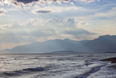 Scenic view of sea and mountains against sky