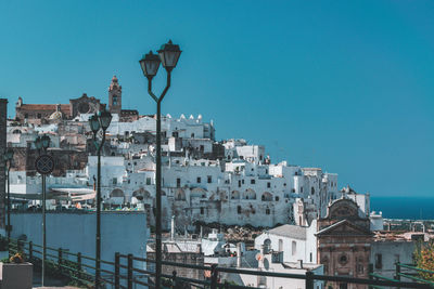 Buildings in city against clear blue sky