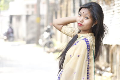 Portrait of young woman in sari standing on street