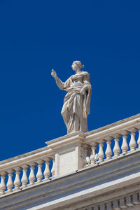 Low angle view of statue against blue sky