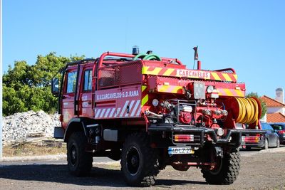 Vehicles on road against clear sky