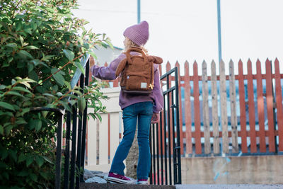 Young girl stood at the top of a step looking after school thinking