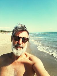 Shirtless mature man standing at beach