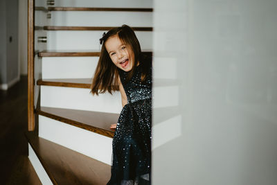 Young woman standing against wall at home