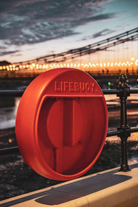 Close-up of illuminated sign in city against sky