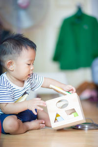 Cute boy playing with toy on floor