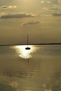 Lone silhouette boat in calm sea