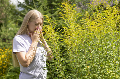 Side view of woman standing against plants