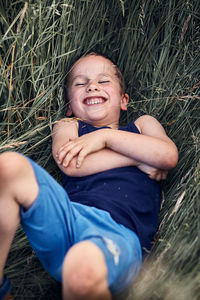 Portrait of smiling boy lying on grassy field