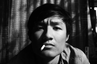 Portrait of young man smoking cigarette