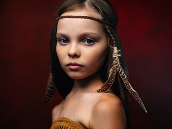 Portrait of beautiful young woman against black background