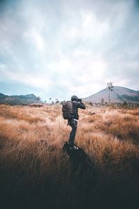 Man standing on field against sky