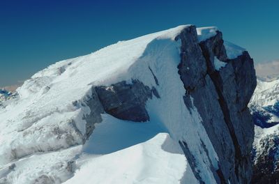 Scenic view of snowcapped mountains against clear blue sky