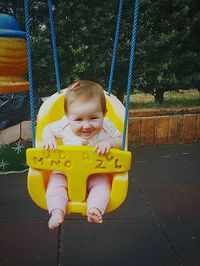 Boy sitting on swing at playground