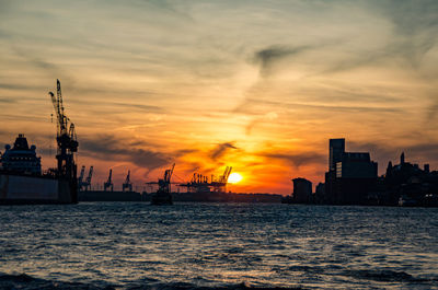 Scenic view of sea and harbor against sky during sunset