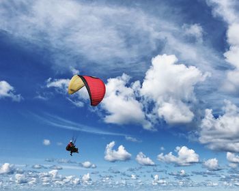 Low angle view of person paragliding against sky