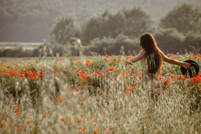 Woman with flowers on field