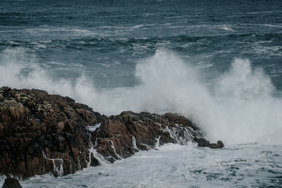 Waves splashing on rocks by sea