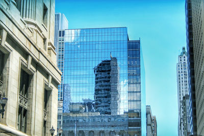 Low angle view of modern buildings against clear blue sky