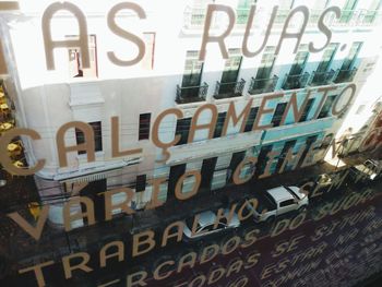 Low angle view of text on glass wall