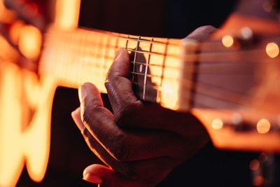 Midsection of man playing guitar at music concert