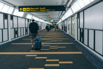 Tourists walking with luggage in don mueang airport thailand.