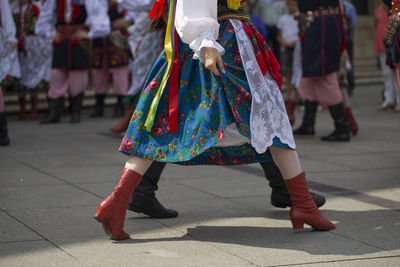 Low section of people dancing on street in city