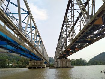 Low angle view of bridge over river against sky