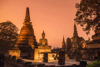 Temple against buildings at sunset