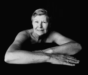 Portrait of shirtless man against black background