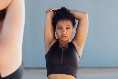 Portrait of young woman standing against white background