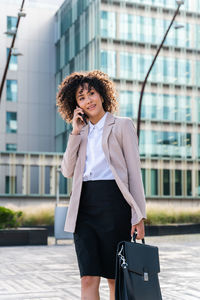 Portrait of young woman standing in city