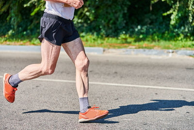 Low section of man running on road