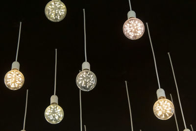 Low angle view of illuminated pendant light hanging from ceiling