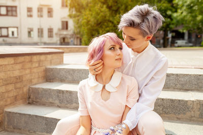 Lesbian couple romancing on steps in city