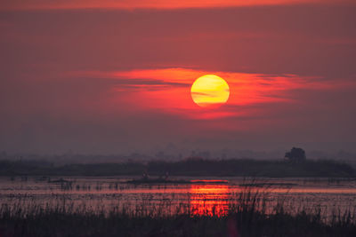 Scenic view of lake against romantic sky at sunset