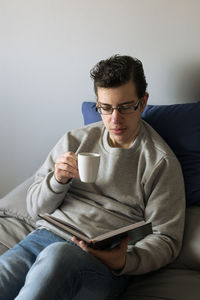 Young woman using laptop while sitting on sofa at home
