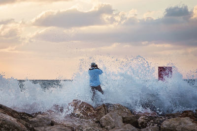 Waves splashing against man