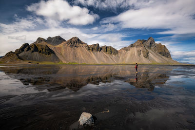 Scenic view of lake by mountains against sky