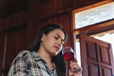 Portrait of a beautiful young woman drinking glass