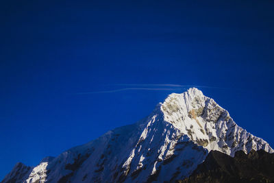 Scenic view of snowcapped mountains against clear blue sky