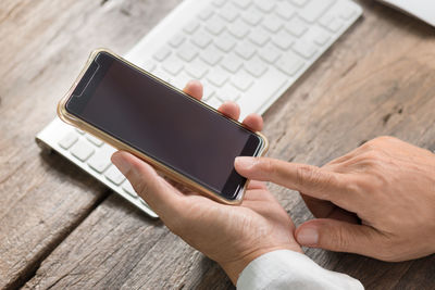 Close-up of man using mobile phone on table