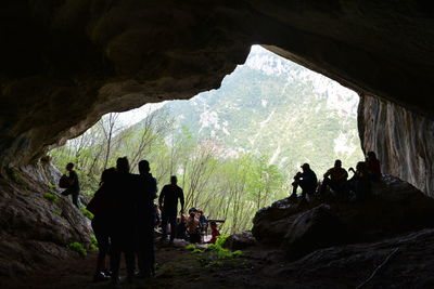 Silhouette people standing in cave