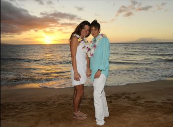 Woman standing at beach against sky during sunset