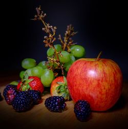 Close-up of apples on table against black background