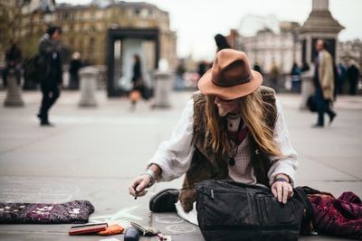 Midsection of woman with umbrella in city