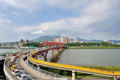 High angle view of bridge over river by buildings against sky